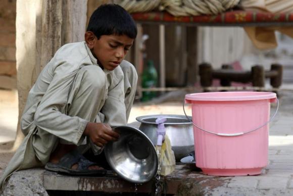 Menino trabalha em loja de alimentao em Peshawar, no Paquisto. Foto: Arquivo/Arshad Arbab/EFE