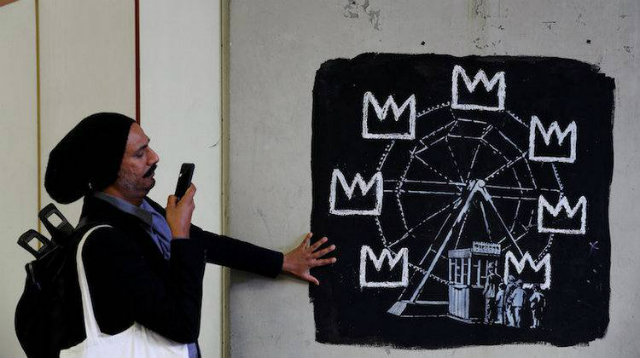 Grafite mostra uma roda-gigante com coroas em vez de gndolas. Foto: AFP/Reproduo