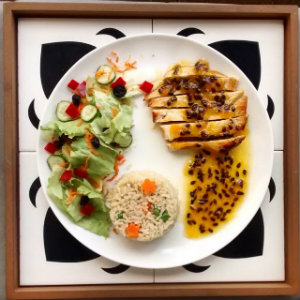 Frango grelhado com molho reduzido de maracujá com as guarnições de arroz integral à grega e a salada do dia. Foto: Dom Sain/Divulgação Frango grelhado com molho reduzido de maracujá com as guarnições de arroz integral à grega e a salada do dia. Foto: Dom Sain/Divulgação
