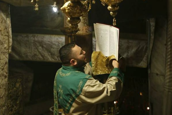 Um homem palestino reza na Igreja da Natividade. Fotos: AFP