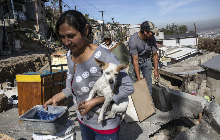 Pessoas deixam suas casas aps deslizamento de terra que causou danos no bairro de Lomas del Rubi, em Tijuana, no noroeste do Mxico. Foto: Guillermo Arias / AFP