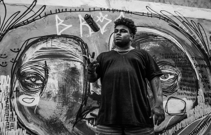 .bros em frente da obra Saudade de que (2018), graffiti que foi resultado de uma performance na Rua da Saudade (Foto: Thallyta Tavares/Divulgao)