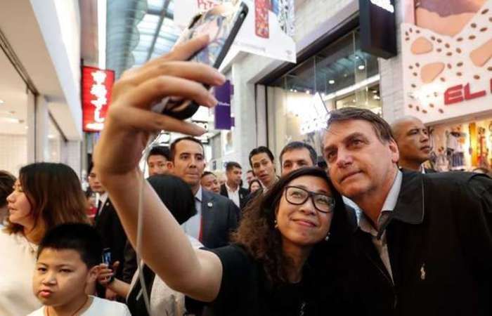 Jair Bolsonaro atende apoiadores brasileiros em Osaka: irritao com jornalistas e resposta rspida para chanceler da Alemanha. Foto: Alan Santos / PR