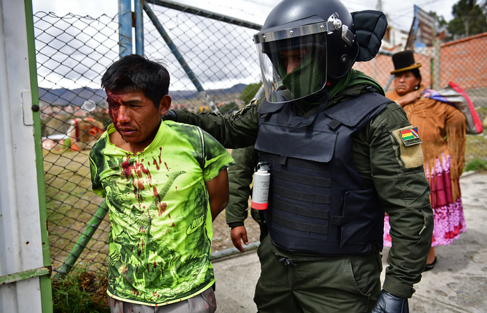 Um policial prende um apoiador do ex-presidente Evo Morales em La Paz nesta segunda (11) (Foto: RONALDO SCHEMIDT / AFP)