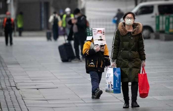 Menino com caixa na cabea para se proteger do COVID-19, em Xangai: nova metodologia de diagnstico permitir tratamento mais cedo (Foto: AFP / NOEL CELIS)