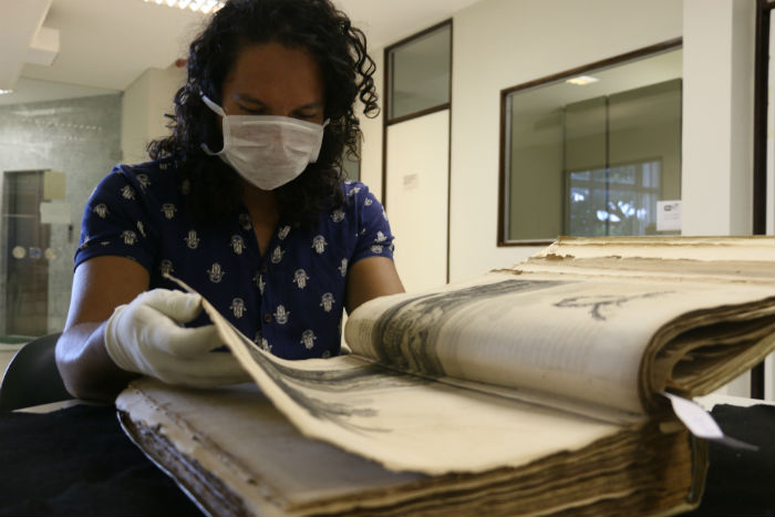 Para manusear as obras raras  preciso usar luvas e mscara, disponibilizadas pela equipe. (Foto: Gabriel Melo/Esp. DP)