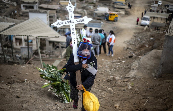 Parente de uma vítima da Covid-19 carregando uma cruz em cemitério de Lima, no Peru (Foto: Ernesto Benavides/AFP) Parente de uma vítima da Covid-19 carregando uma cruz em cemitério de Lima, no Peru (Foto: Ernesto Benavides/AFP)