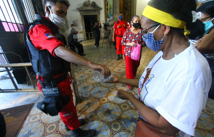 Fiéis recebem álcool em gel na entrada e saída da basílica; uso de máscara é obrigatório. (Foto: Bruna Costa/Esp. DP.) Fiéis recebem álcool em gel na entrada e saída da basílica; uso de máscara é obrigatório. (Foto: Bruna Costa/Esp. DP.)