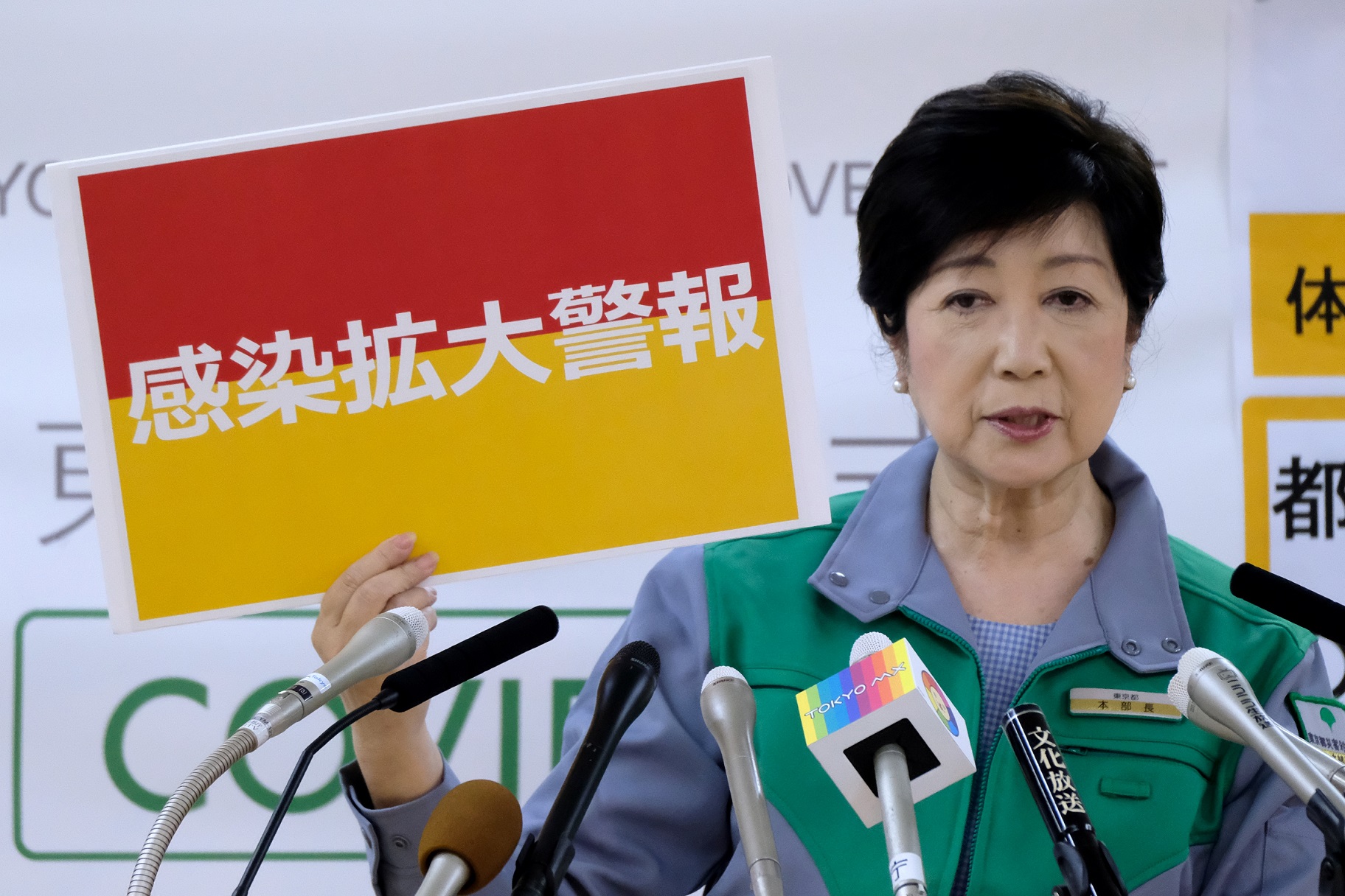  (Governadora de Tquio, Yuriko Koike, segura uma placa que sinaliza "alerta de propagao de infeco". Foto: Kazuhiro NOGI / AFP)