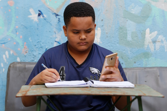 Joo Paulo usa o Google Classroom no celular e usa a rede privada de casa ou o Wi-Fi do Porto Digital. (Foto: Leandro de Santana/Esp.DP)