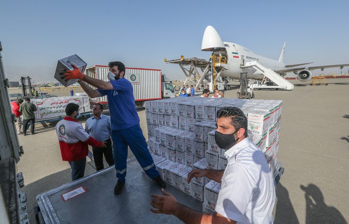 Trabalhadores do Crescente Vermelho Iraniano carregam um avio com ajuda ao povo libans na pista do aeroporto de Mehrabad, na capital Teer (Foto: Atta Kenare/AFP)