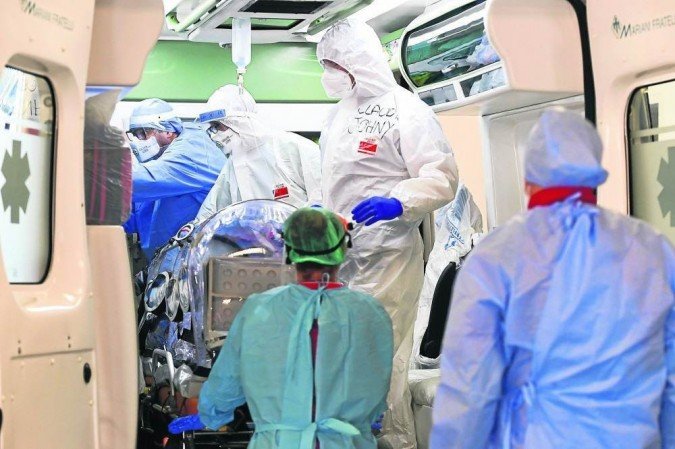  (Equipe de hospital em Milo retira paciente infectado pelo Sars-CoV-2 de ambulncia: aps restabelecimento, 16% tm sinais depressivos. Foto: Miguel Medina/AFP )