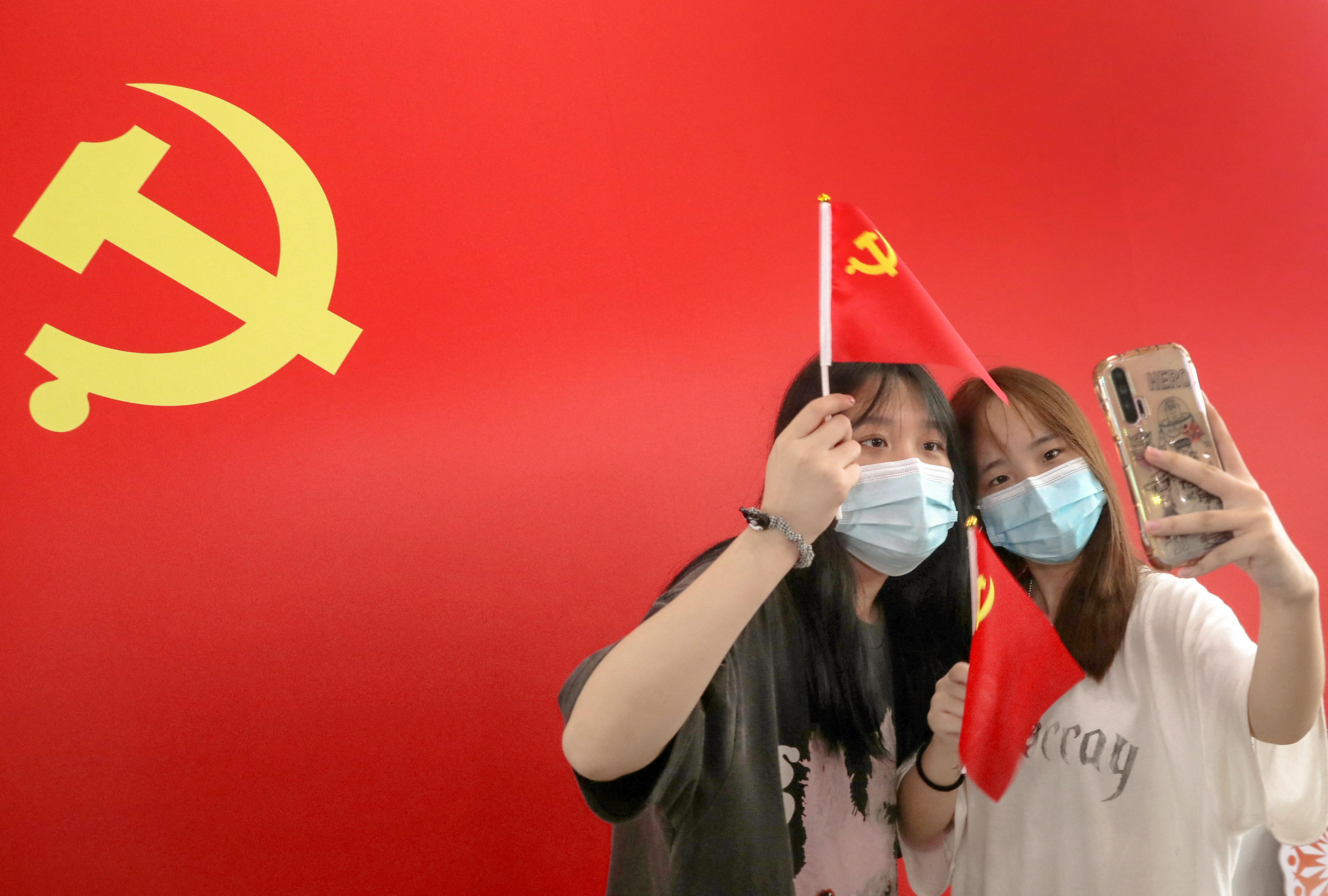 Dezenas de milhares de espectadores cuidadosamente escolhidos,aplaudem a passagem da bandeira gigante na imensa Praa da Paz Celestial (Tiananmen) (Foto: AFP/Divulgao)