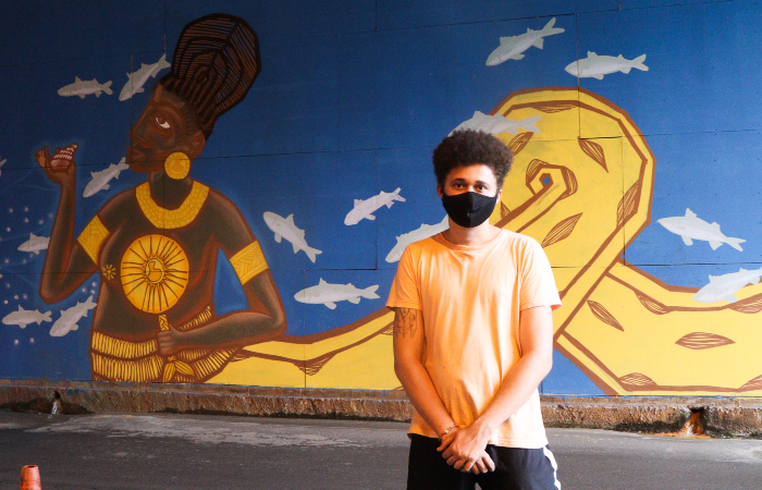 Emerson Crazy traz ancestralidade e vivncia com a f em painel composto por dois homens ao centro de uma floresta com fundo dourado (Foto: Priscilla Melo/Divulgao)