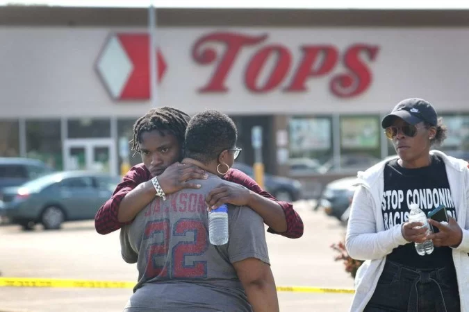 Moradores de Buffalo se abraçam diante do Tops Friendly Markets, no dia seguinte ao tiroteio em massa: cidade em choque após crime de ódio (Foto: Scott Olson/Getty Images/AFP)
