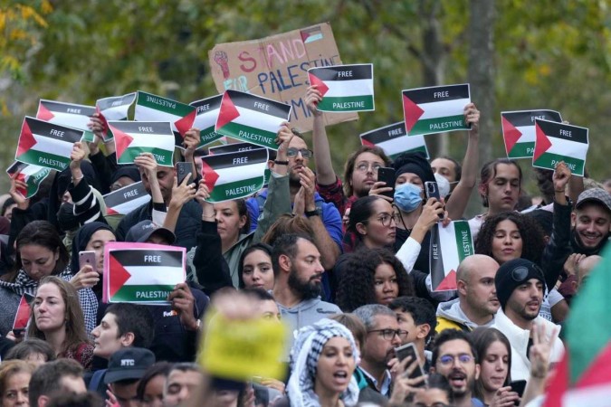 Os manifestantes seguram cartazes "Palestinos Livres" enquanto se reúnem na Place de la Republique durante uma manifestação não autorizada em apoio aos palestinos em Paris (Foto: Dimitar DILKOFF / AFP)