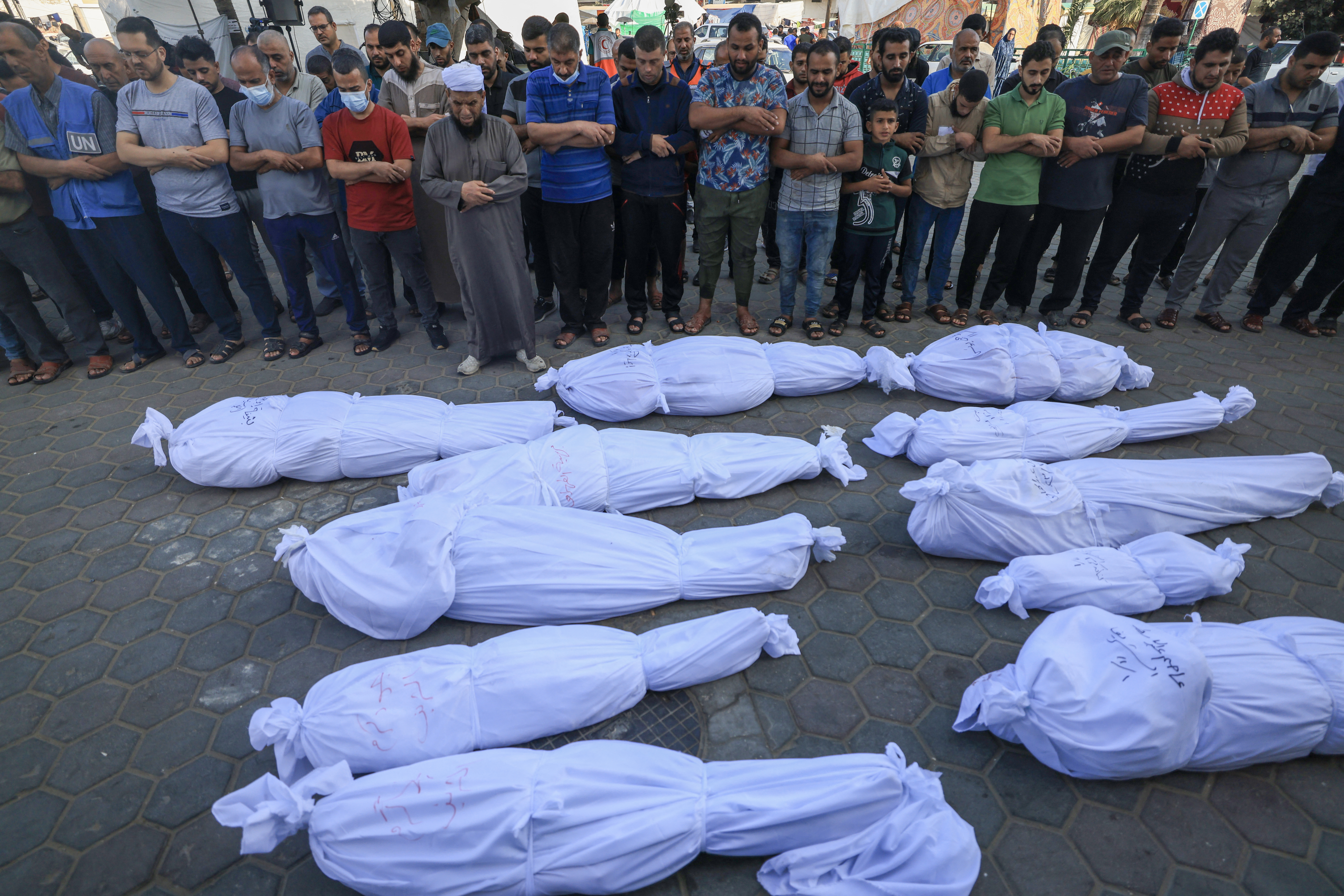 Palestinos rezam pelos corpos de parentes mortos aps bombardeio israelense
 (Crditos: MAHMUD HAMS / AFP)