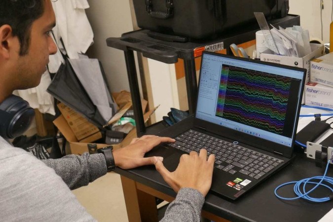 

No laboratrio, Duke University Ph.D. o candidato Kumar Duraivel analisa um conjunto colorido de dados de ondas cerebrais. Cada matiz e linha exclusivos representam a atividade de um dos 256 sensores, todos registrados em tempo real no crebro de um paciente na sala de cirurgia (foto: Dan Vahaba/Duke University/Divulgao )